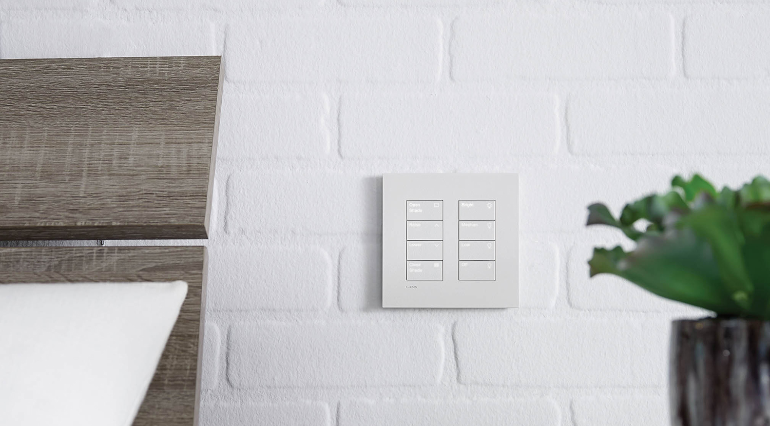 White, Lutron Palladiom Roller Shade Keypad with, 2, 4-button columns, on a white brick wall