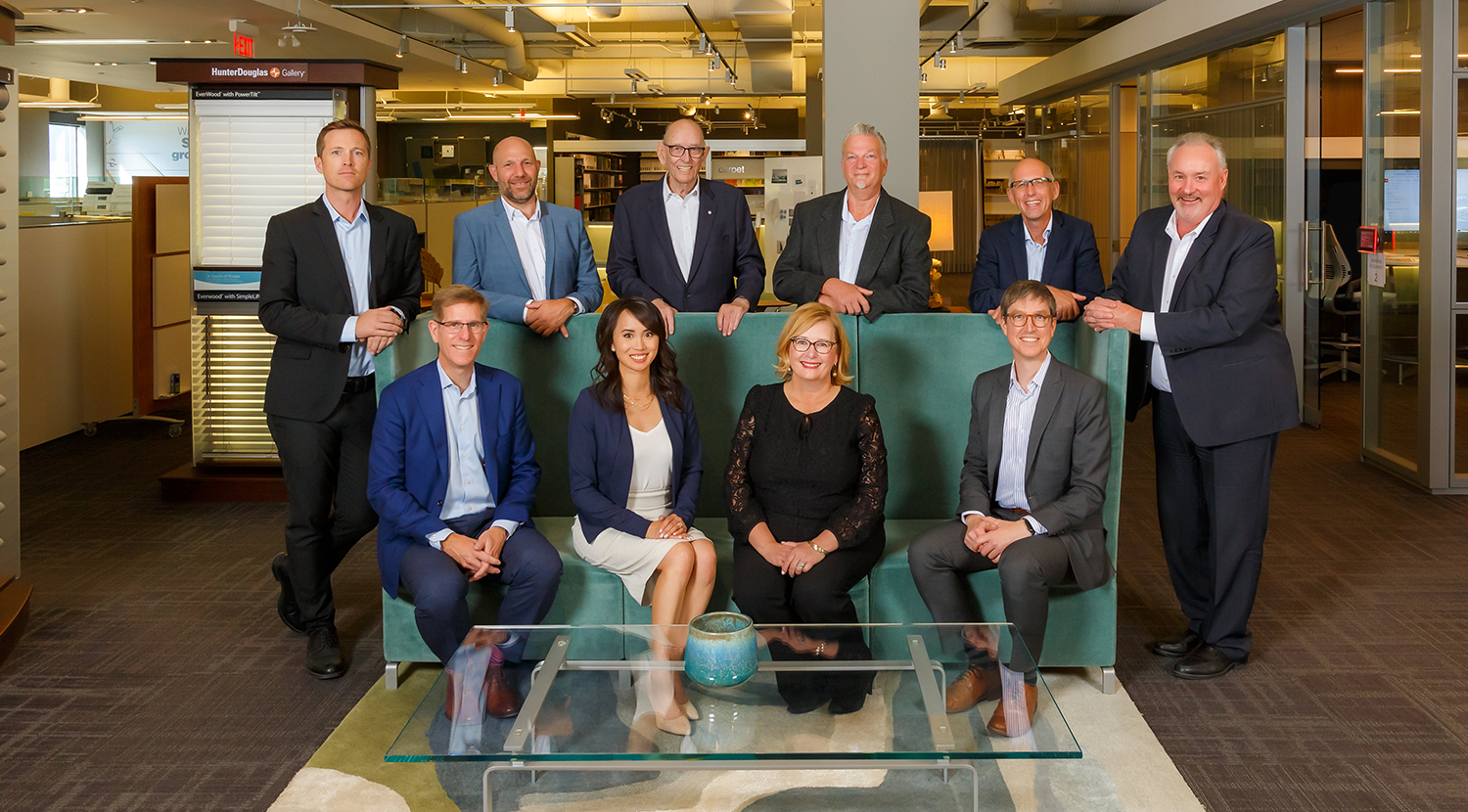 RGO Calgary senior management team seated and standing around a green sofa