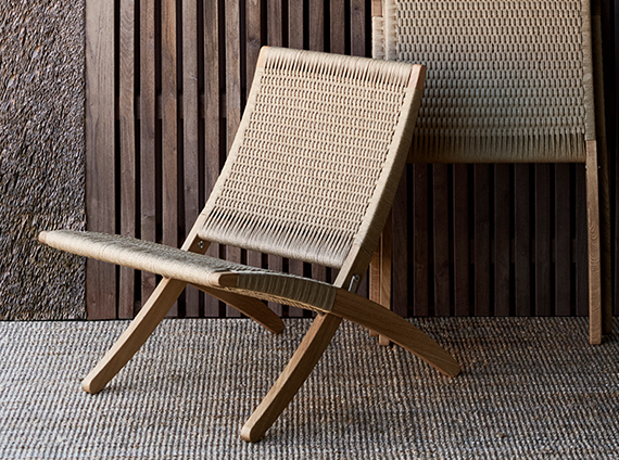 Carl Hansen and Son Cuba chair, in a tan color, and made with cotton webbing on an outdoor rug