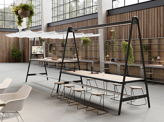Two standing and seated Extremis A-frame tables, with a black frame and oak veneer tabletop in an industrial building