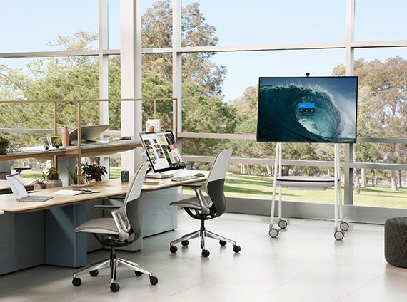 Variety of Microsoft electronic devices, around steelcase tables, chairs and TV media cart
