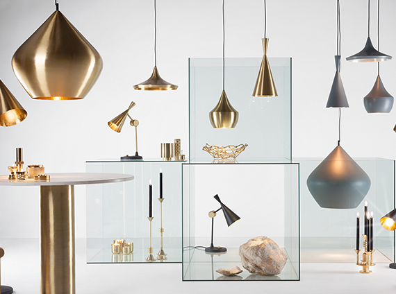 Collection of uniquely shaped metallic light fixtures and desk lamps by Tom Dixon, in a white toned room
