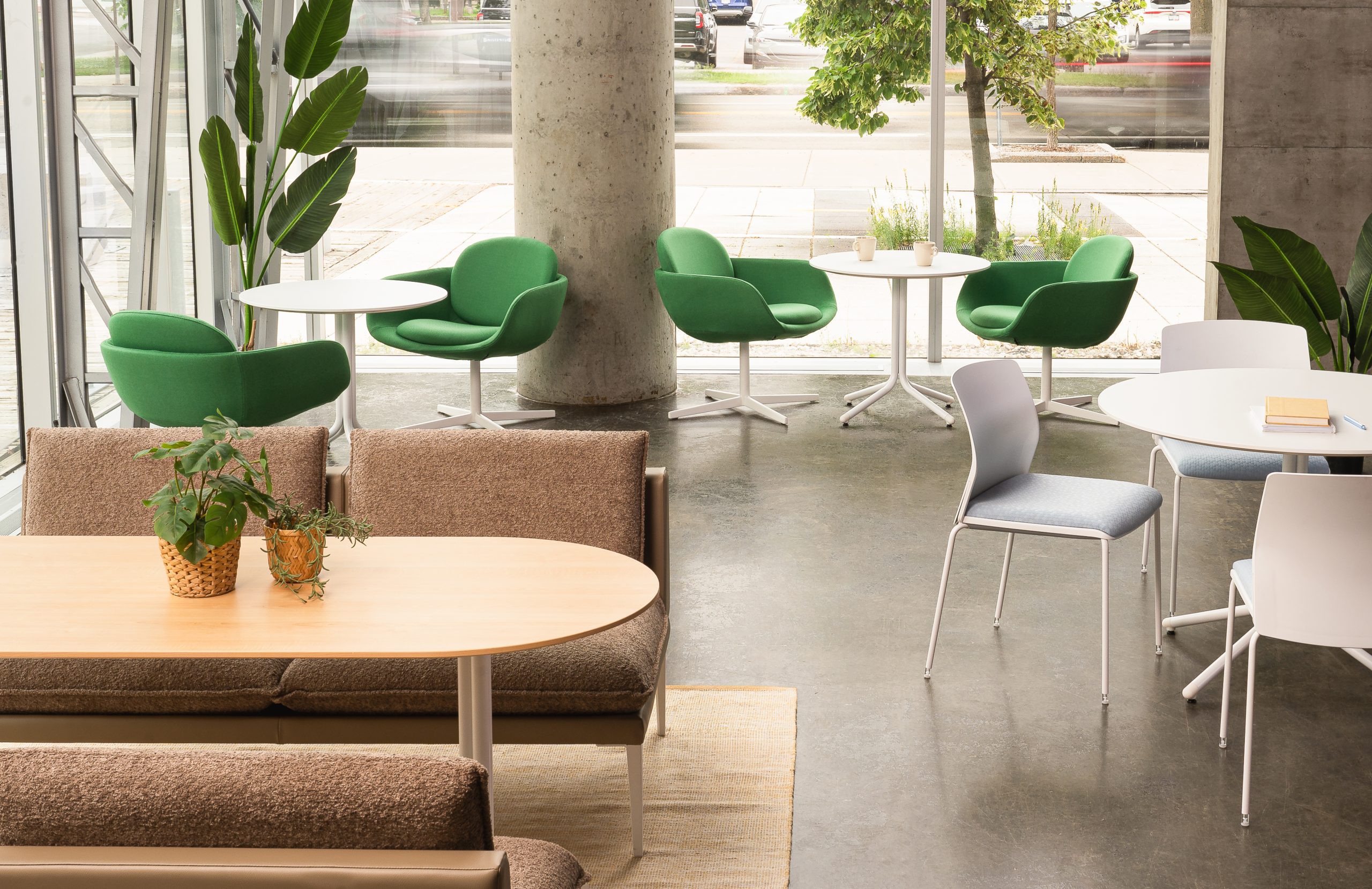 A work cafe with mix of tables, sofas and chairs in front of a large window