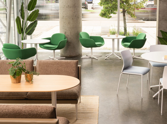 A work cafe with mix of tables, sofas and chairs in front of a large window