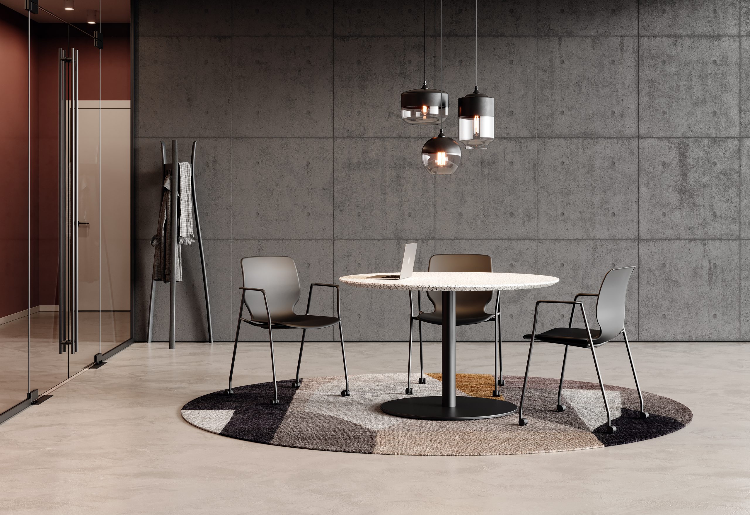 Three black chairs with casters in a meeting room around a round table with an open laptop