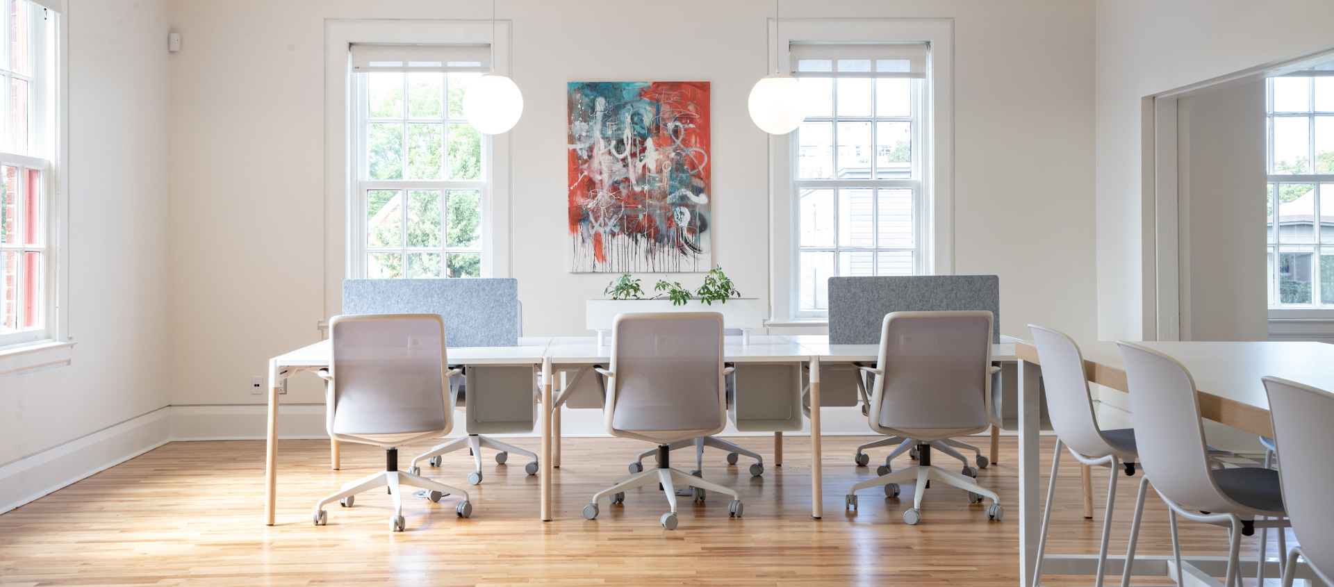 Benching system of 6 workstations with chairs in a white open space