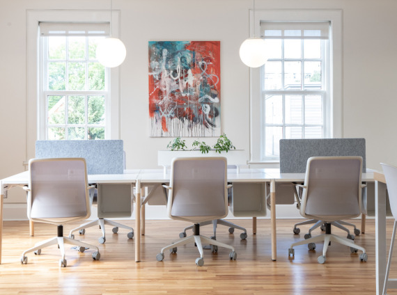 Benching system of 6 workstations with chairs in a white open space