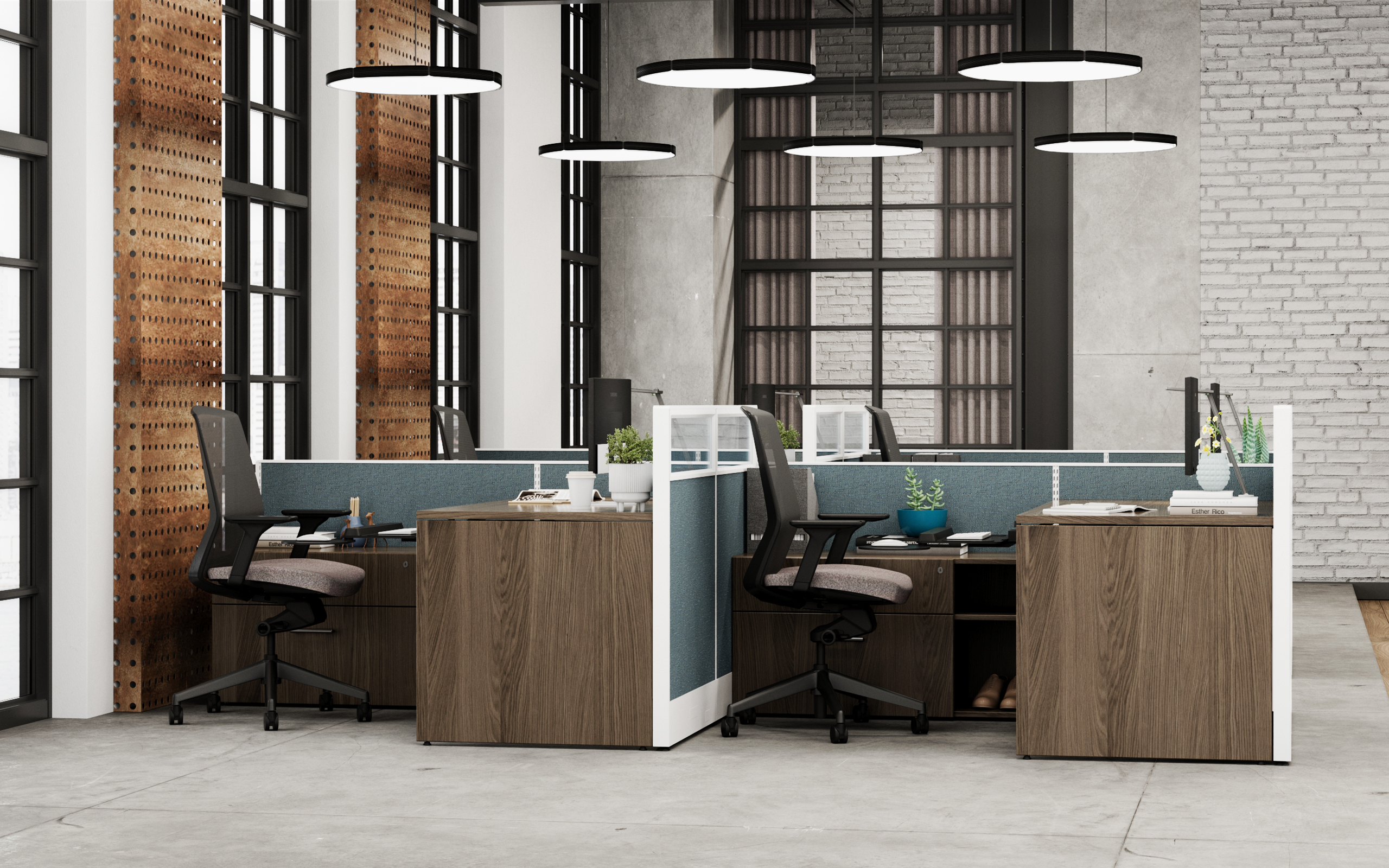 A image of 4 work stations, dark brown wood tone desks; black chairs and blue/white cubicle walls